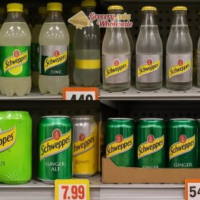 A collage of different Schweppes products with varied flavors and packaging, illustrating pricing differences across regions.